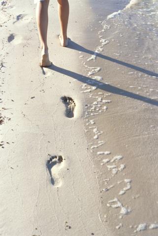 Footprints in sand near water