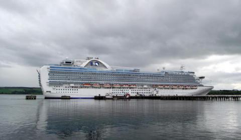 A large cruise ship alongside a pier.