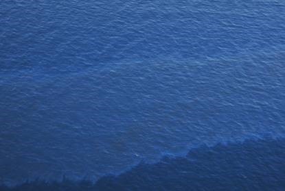 A sheen resulting from a release or discharge of a hydrocarbon-based liquid. © Maritime and Coastguard Agency.