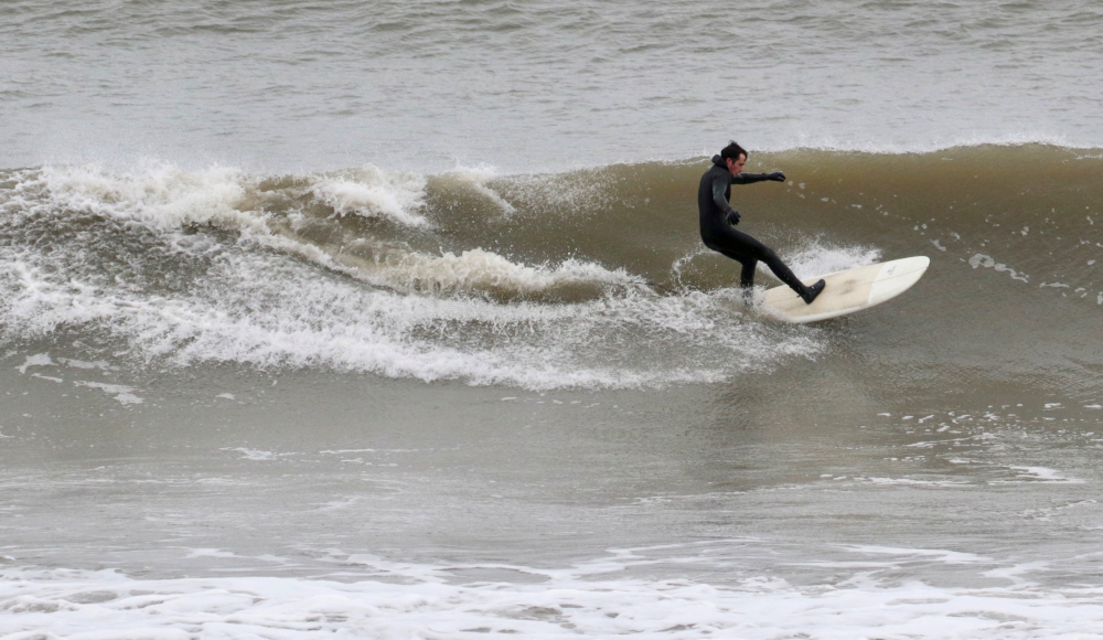 A surfer taking advantage of the waves at a Scottish beach in November. Climate change may increase opportunities for the tourism and marine activities sector with warmer air and sea temperatures making seaside visits more attractive.